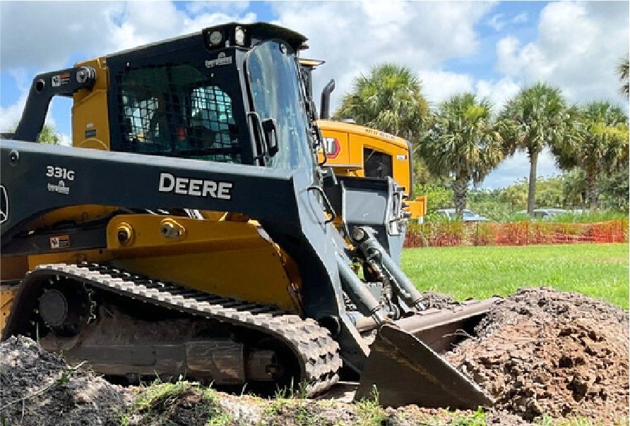 Skid steer clearing debris on a property